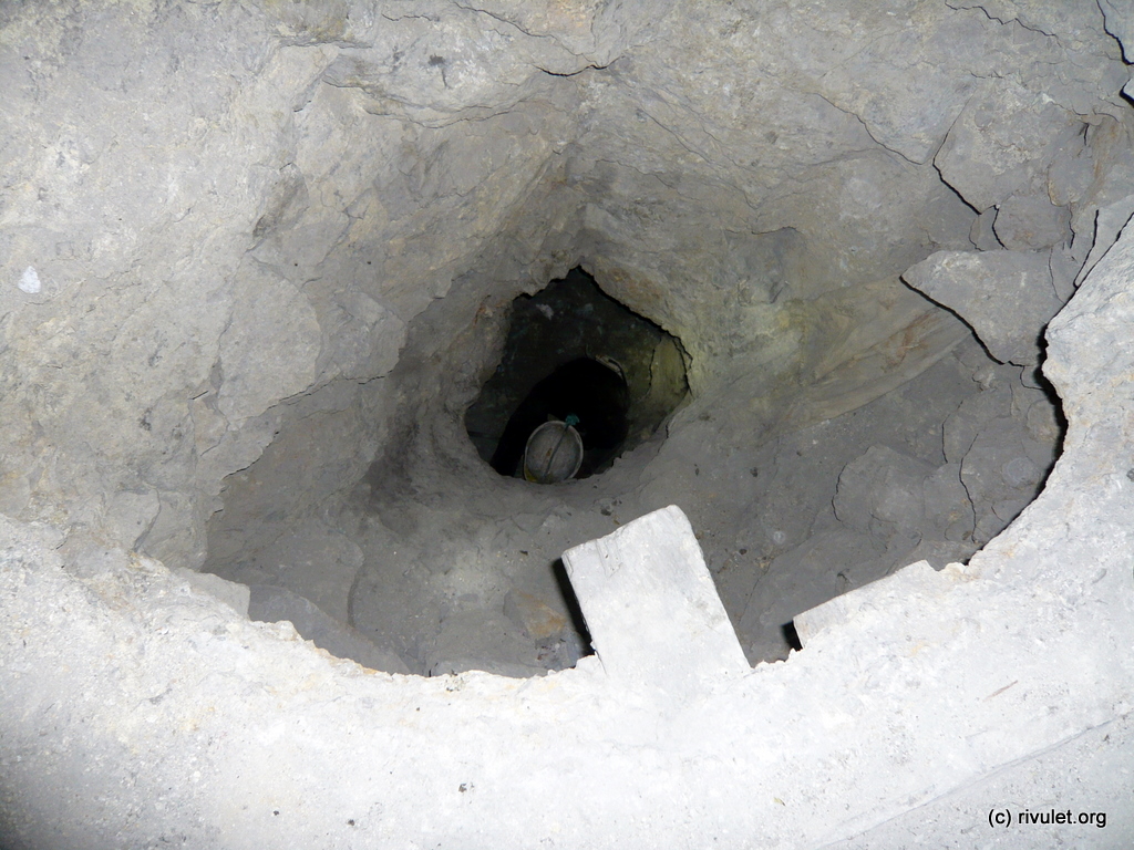 A miner working in a deep hole.
